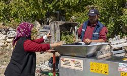 Üzüm sıkma makinesi çalışıyor, üretici keyfine bakıyor