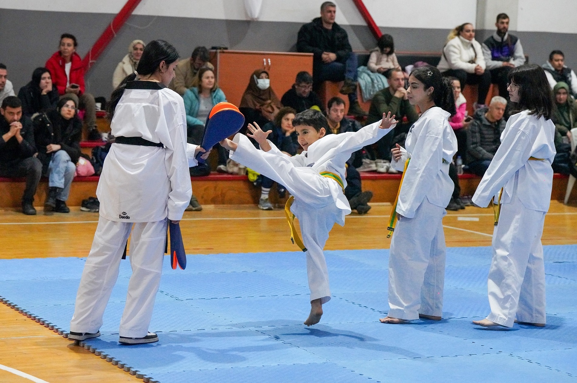 Gaziemir Belediyesi'nin düzenlediği taekwondo kursuna katılan 100 sporcu, yeteneklerini sergileyerek bir üst kuşağa çıktı.