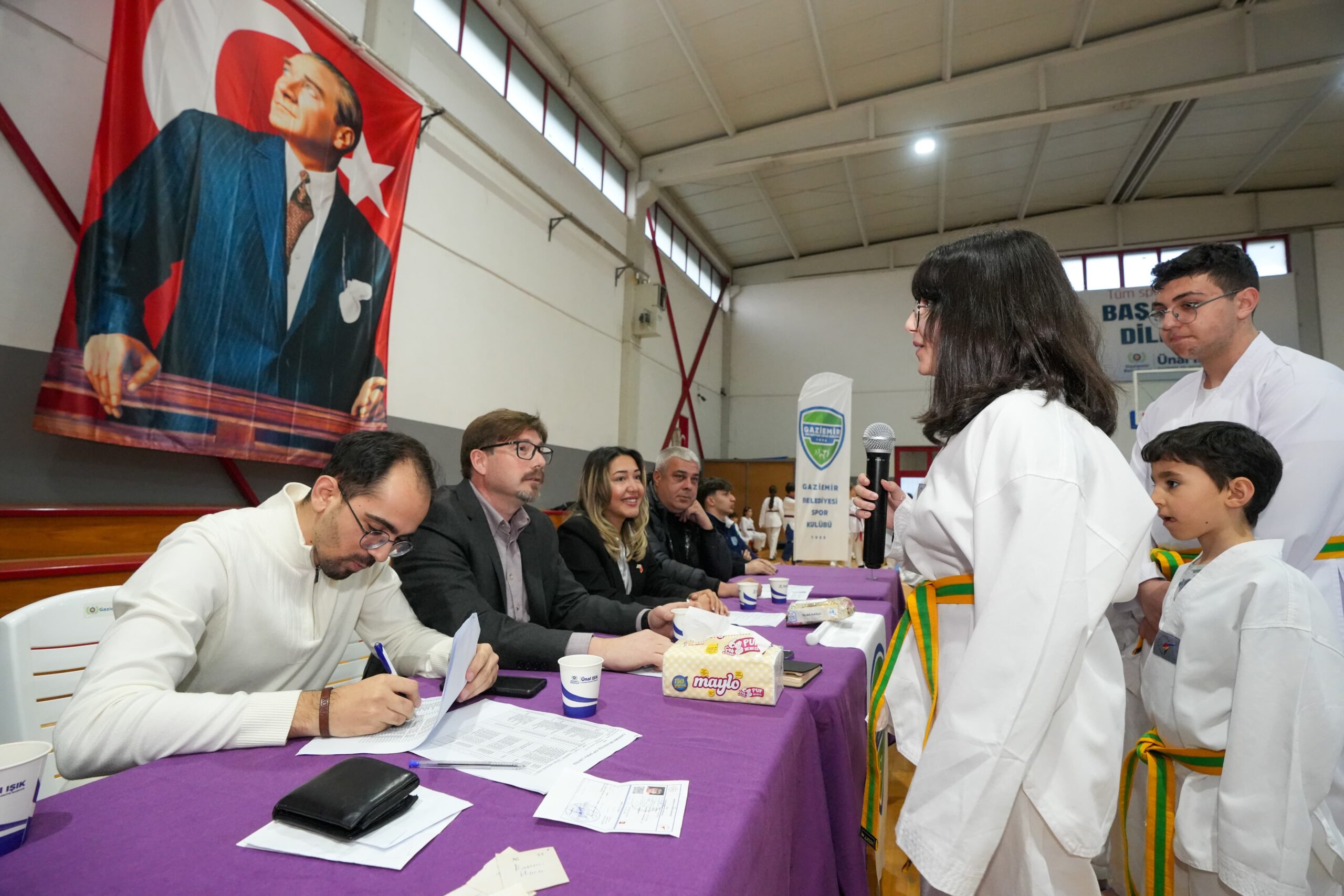 Gaziemir Belediyesi'nin düzenlediği taekwondo kursuna katılan 100 sporcu, yeteneklerini sergileyerek bir üst kuşağa çıktı.